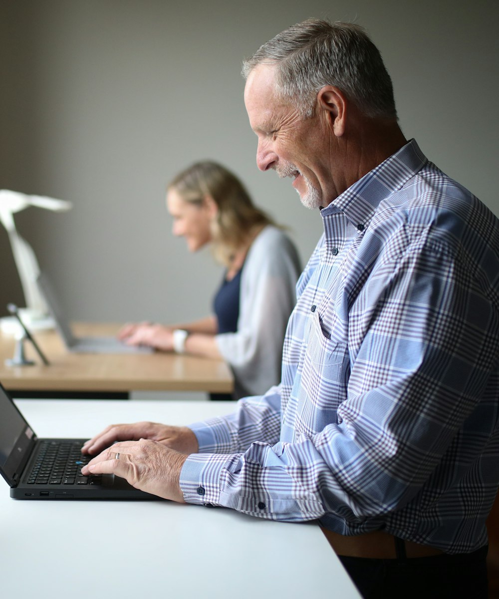A man working on a laptop at a desk by a window