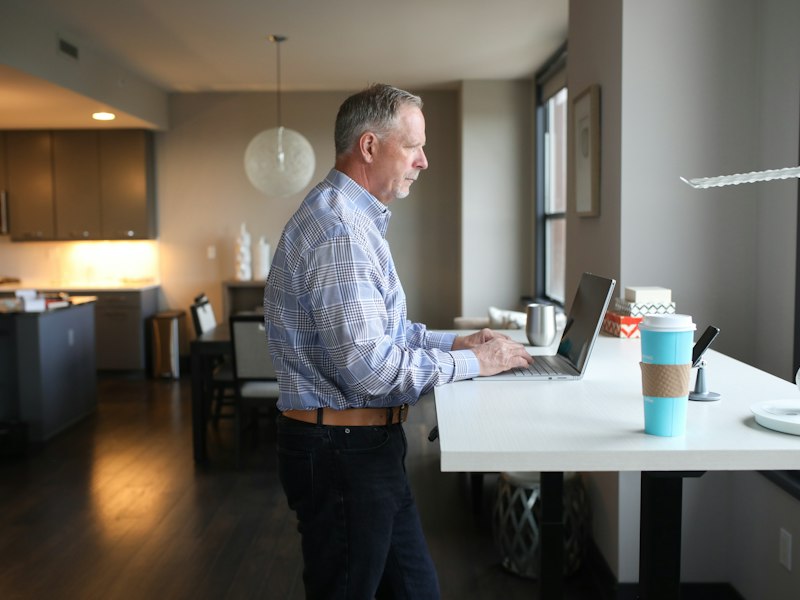 A man working at a standing desk in a bright office